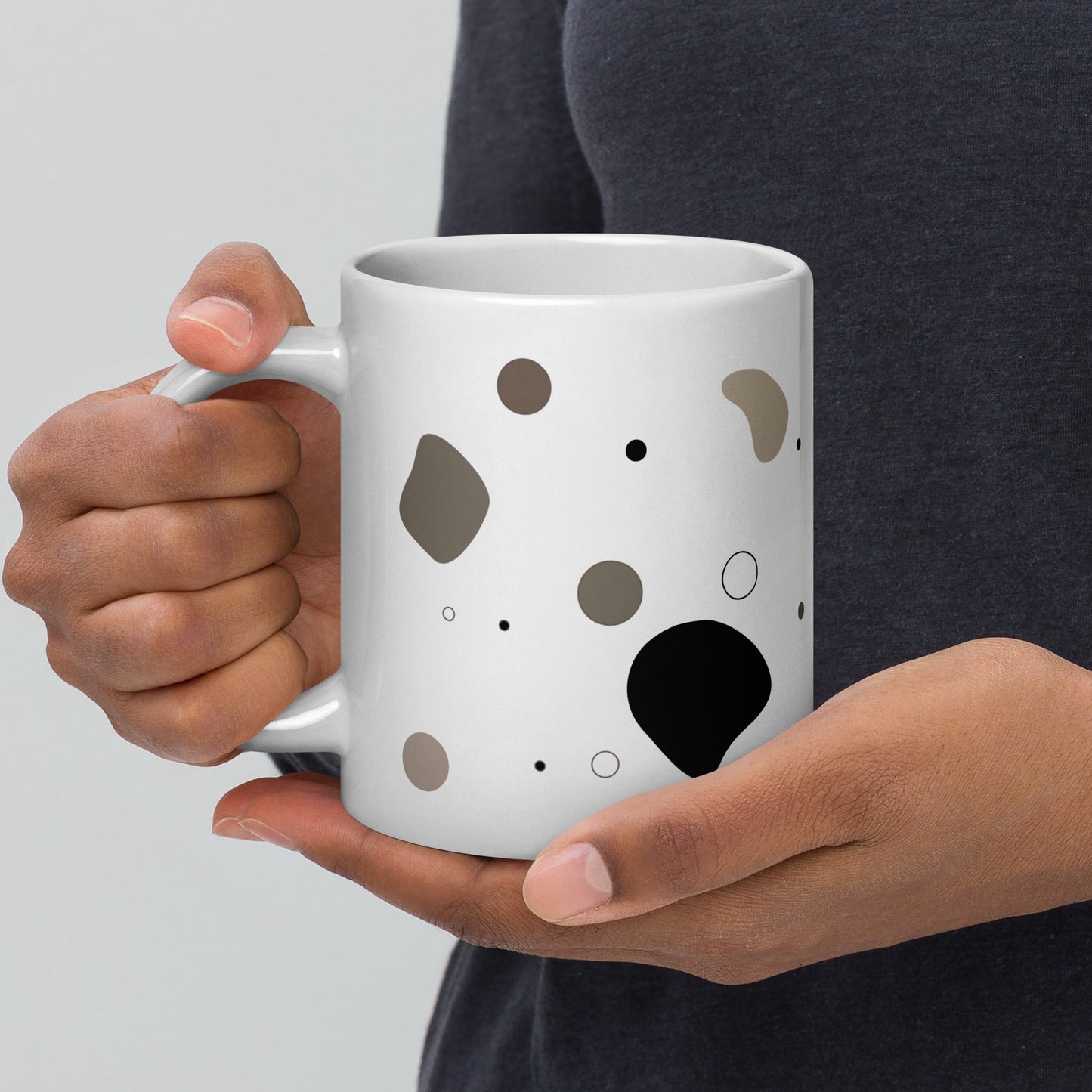 Person holding the Pebble white glossy ceramic mug, 20 oz, with abstract neutral pattern by Lumine Studio