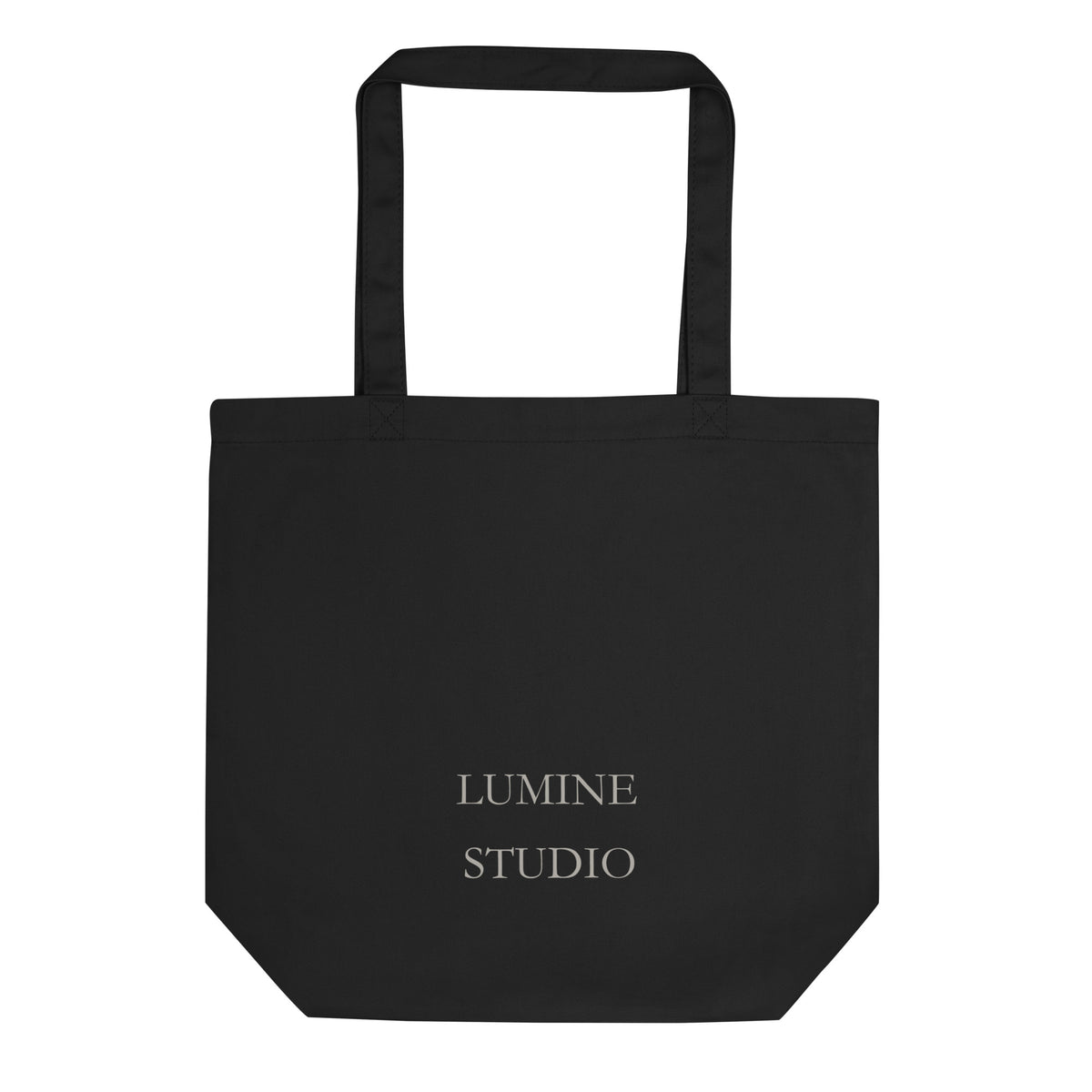 Black eco tote bag shown from the black with a minimalist Lumine Studio logo print