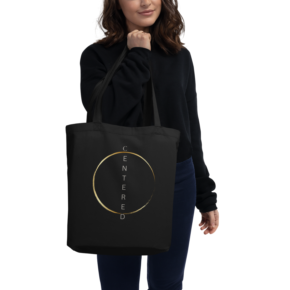 woman carrying a black eco tote bag with a minimalist gold circular design