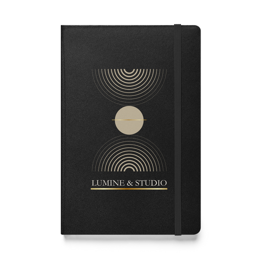 Black Lumine Studio hardcover notebook with minimalist gold geometric design, front view