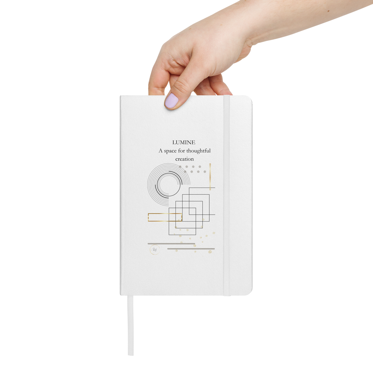 Hand holding the white Lumine hardcover notebook with A space for thoughtful creation text and minimalist geometric design