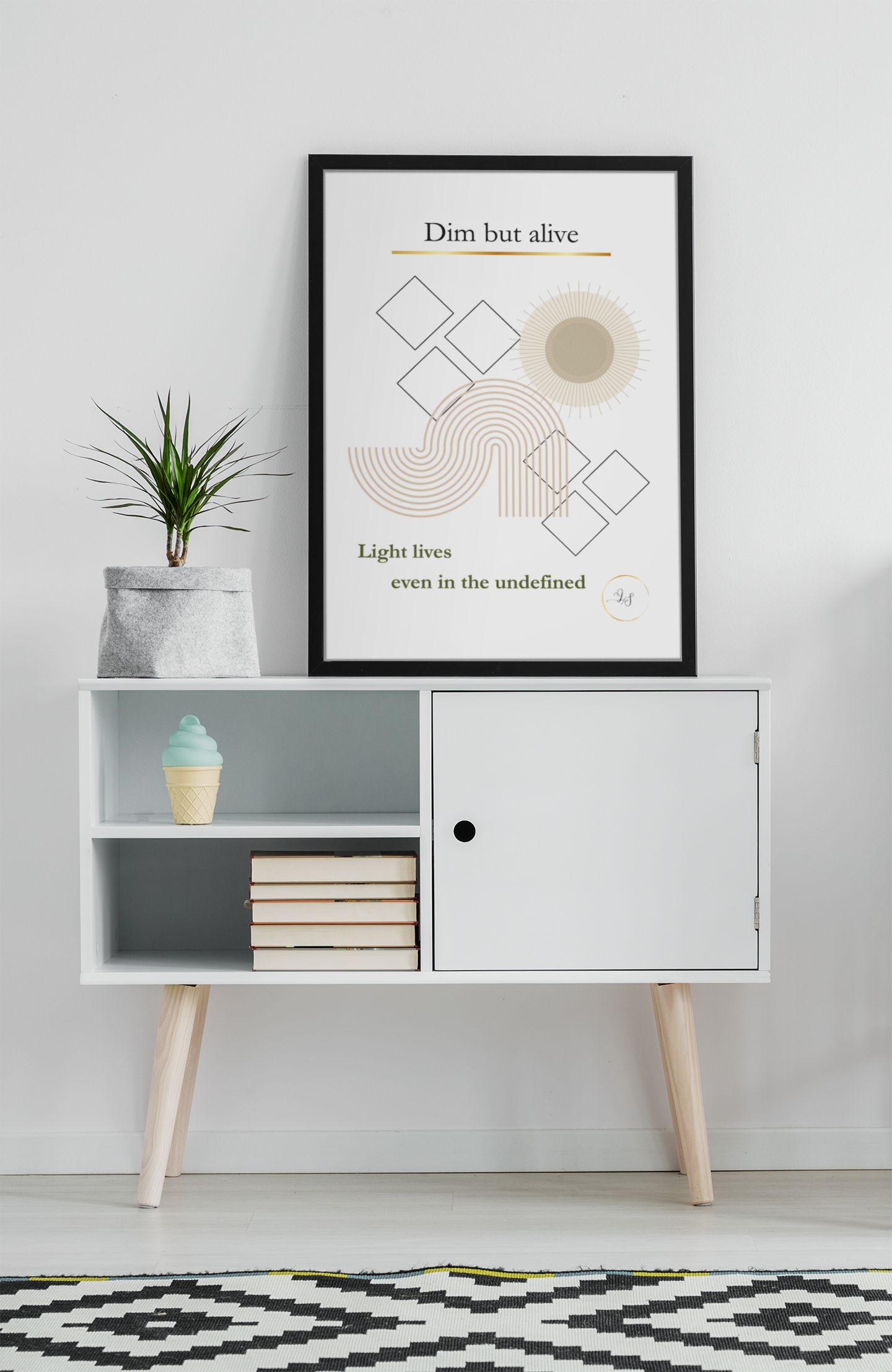 Minimalist geometric wall art displayed above white cabinet with books and small plant