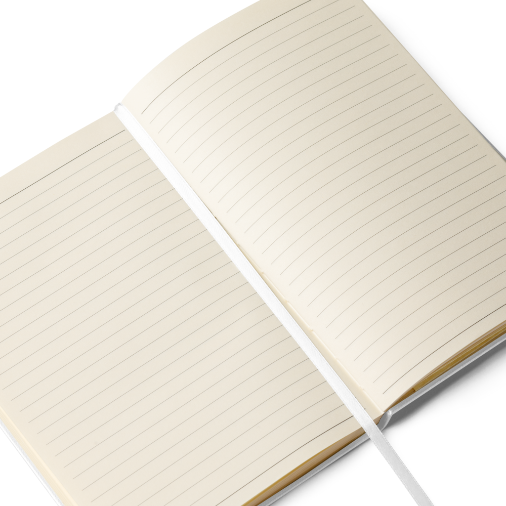 Open white hardcover notebook showing cream lined pages and a white ribbon bookmark
