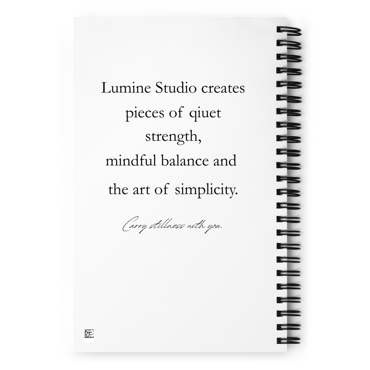 Back view of a white spiral notebook with a minimalist inspirational text design